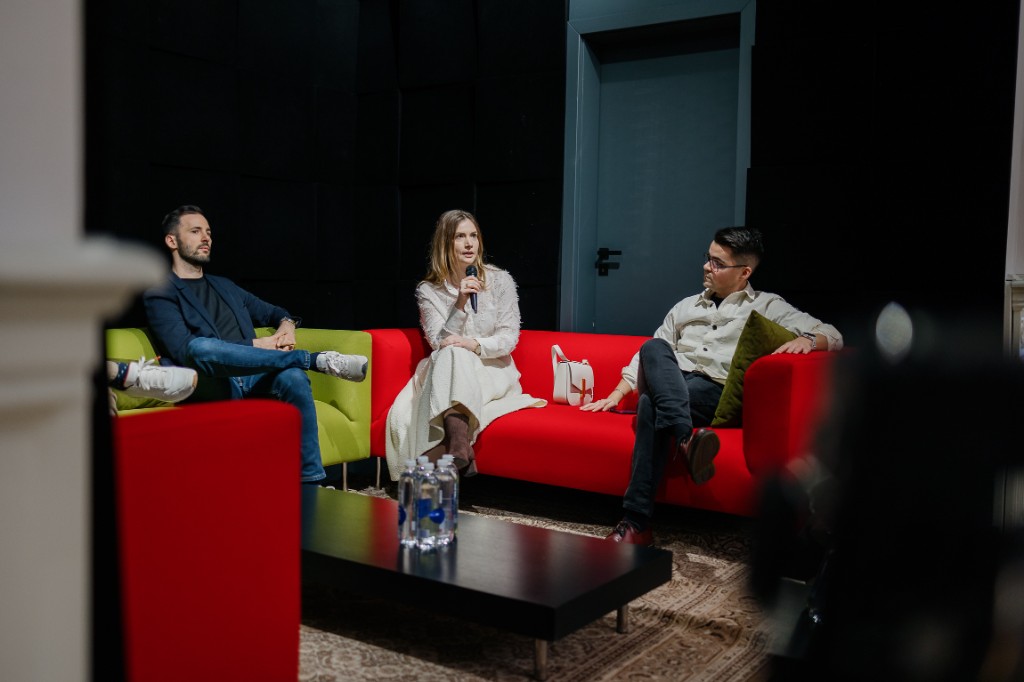 Panel discussion with three speakers on colorful modular seating